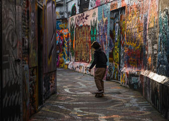 tiener op skateboard in het graffitistraatje