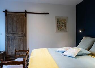 slaapkamer met dubbel bed en houten roldeur