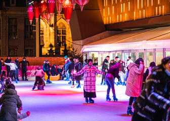 mensen aan het schaatsen op de ijspiste onder de Stadshal