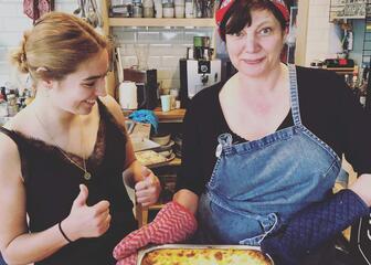 Student and owner Ann making lasagne