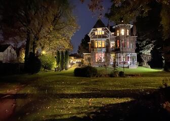 De villa bij nacht met de binnen- en buitenverlichting aan