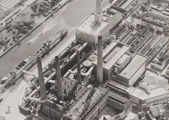Vue aérienne de la centrale électrique de la ville de Ham, située dans le quarti er de Sluizeken-Tolhuis-Ham. Au centre, la centrale électrique et le quartier de maisons ouvrières Ham, aujourd’hui démoli. A l’avant-plan, l’ancienne centrale à charbon avec quatre cheminées et, à gauche, le   Handelsdok. Collection du Musée de l’Industrie 