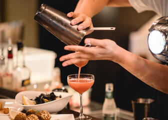 Bar waarop een roze cocktail wordt ingeschonken