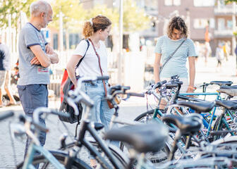 Mensen aan het kijken naar fietsen op de markt