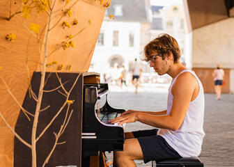 Un hombre toca el piano bajo el pabellón municipal