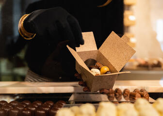 Une femme remplit une boîte de chocolats