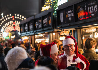 Men at Christmas market dressed as Father Christmas