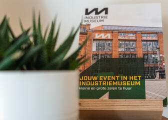 flyer 'jouw event in het industriemuseum' naast plant