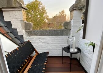 Balkon mit Sitzgelegenheit und Blick auf einen Teil von Gent