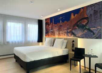 Chambre avec lit double, tête de lit en bois et une peinture de Moebius 