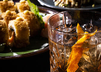 Bild eines Cocktails mit 2 Gerichten im Hintergrund 