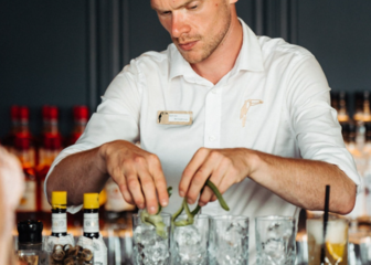 Foto van een barman die cocktails aan het maken is