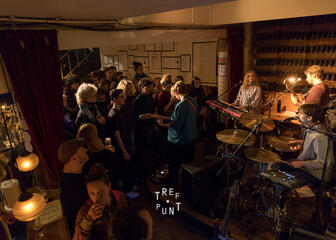Indoor area of the pub with musicians  on the rightside playing for the audience