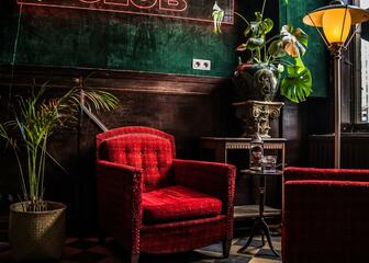 Interieur met rode zetels en donkergroene muur met Havana Club in neon 