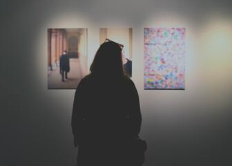 Vrouw kijkt naar de werken van de expo