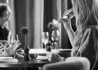 Dame genießt ein Glas Wein in der Gastrobar.