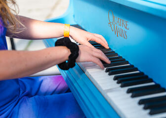 Meisje aan het spelen op een blauwe piano