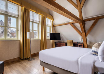 Hotelzimmer mit heller Wand und ockerfarbenen Akzenten