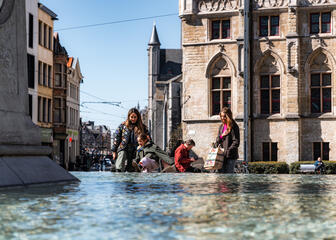 Tiany and family at fountain on Sint-Baafsplein in Ghent on sunny day