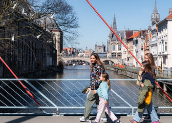 Tiany Kiriloff and her three daughters walk across a bridge on the waterfront in Ghent on a sunny day