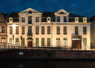 Beleuchtete weiße Villen mit abgestuften Giebeln der Sint-Bavohumaniora in Gent
