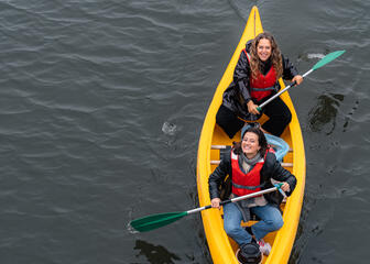 Laura and girlfriend sit together in a canoe to dirt fish at the Oude Dokken in Ghent