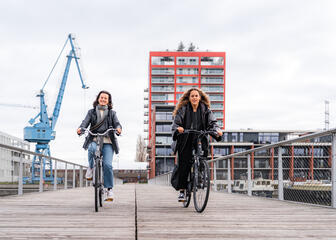 Laura cicla con una amiga sobre el puente de Batavia en el Oude Dokken en Gante