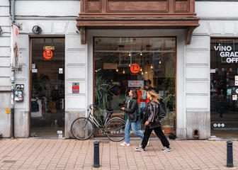 Laura and her girlfriend walk past the window of a second -hand store in Ghent