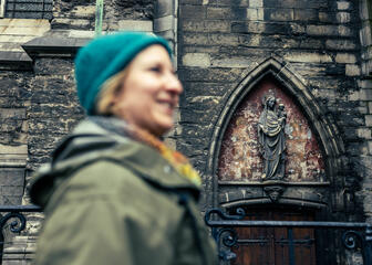Maaike Blancke geht an den Fassaden der St.-Bavo-Kathedrale in Gent entlang