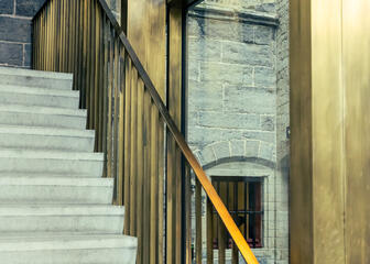 Una escalera de hormigón con pasamanos de latón indica a los visitantes el camino en el nuevo centro de visitantes de la Catedral de San Bavón.