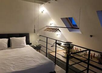 double bed with white sheets in a mezzanine