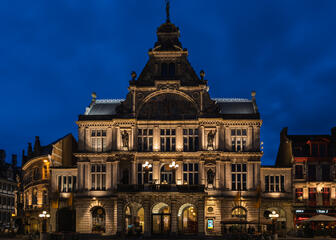 De Konink­lij­ke Neder­land­se Schouw­burg op het Sint-Baafsplein, prachtig verlicht op een heldere avond