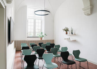 Sala pequeña con mucha luz, plantas y 5 filas de 4 sillas cada una