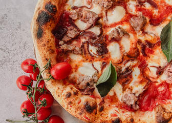 pizza on a white background with mushrooms and tomatoes