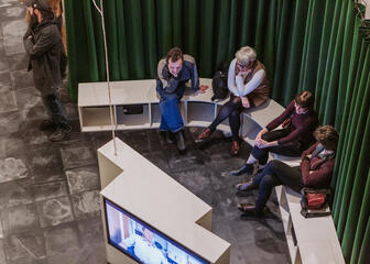Los visitantes de la exposición siguen la información en pantallas de televisión