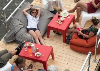 8 people sitting on chairs on a raft on the water