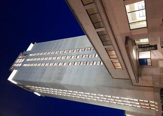 Verlichte toren en bijgebouwen van de Boekentoren in Gent bij valavond