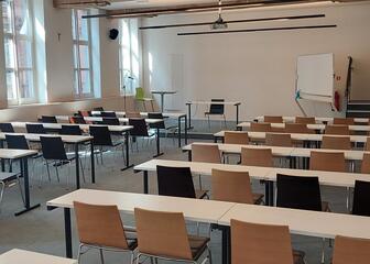 Sala de reuniones con disposición tipo aula y mucha luz natural.