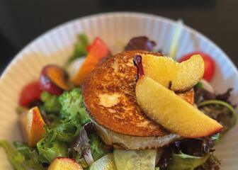 Plato con ensalada, tomate, queso de cabra y fruta