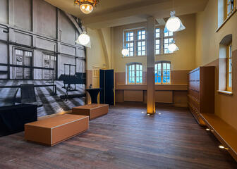 Lobby painted in shades of yellow and brown, with parquet flooring and Art Nouveau ceiling lights