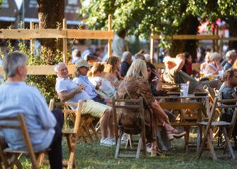 Mensen in de tuin aan een tafel tijdens het Gent Jazz Festival