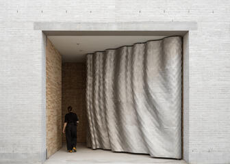 Dame stapt door de indrukwekkende 3D geprinte toegangspoort van Design Museum Gent