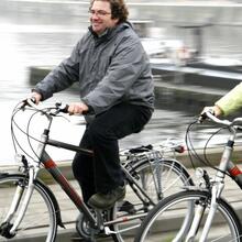 Twee fietsers rijden langs het water.