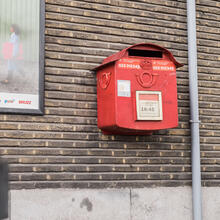 Un buzón de correos colgando en una pared de ladrillos. 