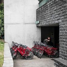 Les vélos rouges de location de la Fietsambassade (Ambassade des vélos) peuvent être emportés. Un mécanicien de vélo répare une roue