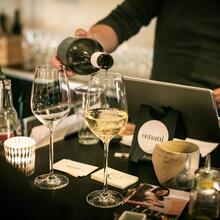 Barman schenkt witte wijn in twee glazen.