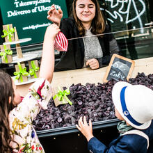 Une vendeuse donne un sac de cuberdons à rayures rouges et blanches à deux enfants sur un étal du Groentenmarkt (Marché des Légumes) à Gand.
