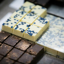 Close-up van pralines in de etalage, pure chocolade pralines en witte met blauwe stippen pralines.