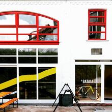 gevel van bataia, wit gebouw met rode en gele accenten