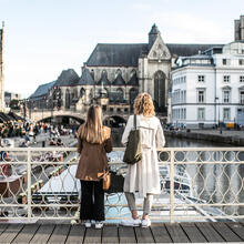 twee vrouwen staan op de Grasleibrug en kijken uit over het water 